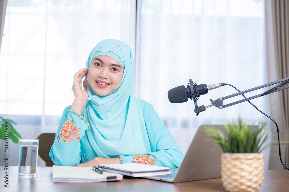 A young Asian woman opening visual aids to give her audience a better understanding while holding a podcast session. A young Asian woman opening visual aids to give her audience a better understanding while holding a podcast session.