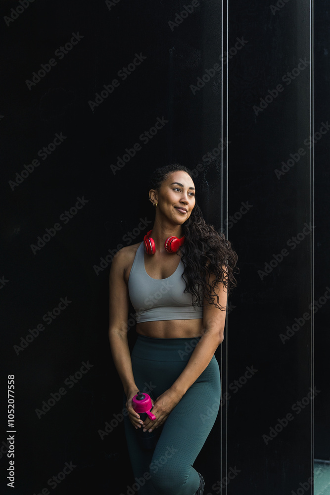 Latin athlete resting after working out holding water bottle Latin athlete resting after working out holding water bottle