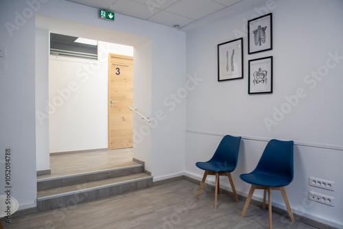 Panorama d'une salle d'accueil et d'attente dans une clinique avec un escaliers, chaises modernes et affiches.  photo