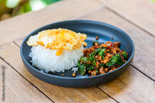 Cuadro en lienzo Spicy fried pork with basil leaves, the famous traditional Thai food served with jasmine rice and fried egg