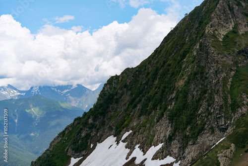 mountain tops with snow and clouds on blue sky photo