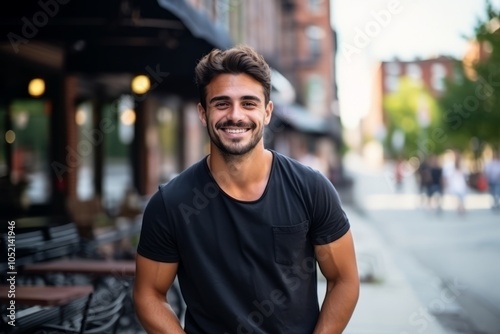 Portrait of a handsome young man smiling at the camera in an urban setting