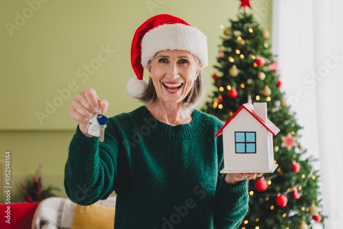 Photo of adorable funny grandmother hold small house keys buy rent new apartment flat celebrating new year miracle gift photo