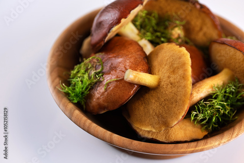 Suillus granulatus mushroom in a wooden bowl on white background. Weeping bolete. photo