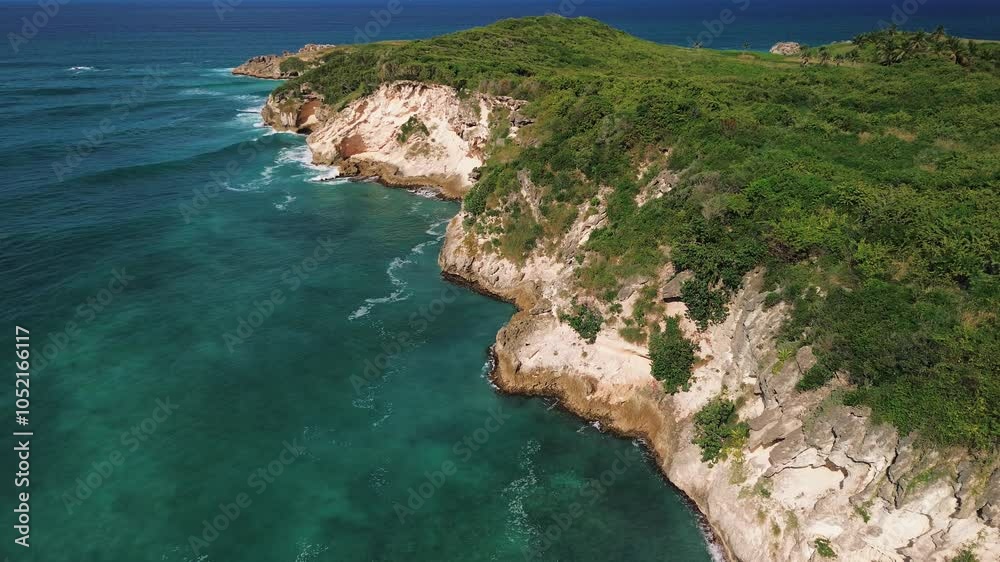 Atrial view of wild tropical coast of the Dominican Republic with rocky cliff and untouched nature.A light breeze rolls onto the shore with turquoise ocean waves.A luxurious landscape for relaxation Atrial view of wild tropical coast of the Dominican Republic with rocky cliff and untouched nature.A light breeze rolls onto the shore with turquoise ocean waves.A luxurious landscape for relaxation
