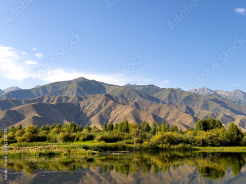 A quiet mountain lake Issyk-Kul, surrounded by green valleys and majestic mountains. The perfect spot for tourism and peaceful relaxation in Kyrgyzstan.