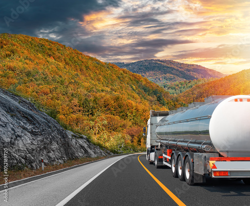 Fuel truck on a picturesque road against the backdrop of an autumn landscape. A tank truck transports fuel. photo