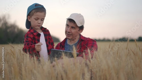 Africulture. Father and son are farmers, growing wheat and working in the field. Family farm farmer concept. Father and child working in a field. Father and son working in a field of wheat lifestyle. photo