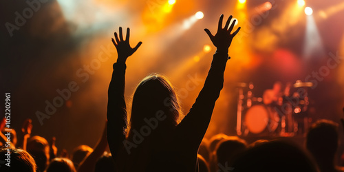 Singer performing on stage with arms up. photo