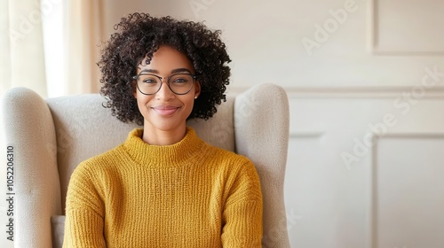 Smiling woman in cozy sweater sitting in armchair