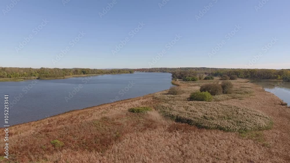 Landscape view of Mohawk River surrounded by autumn grass fields on a sunny day in New York Landscape view of Mohawk River surrounded by autumn grass fields on a sunny day in New York
