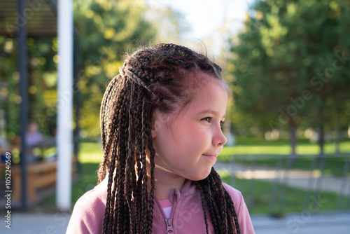 Little girl 10 years old with afro braids in the park. photo