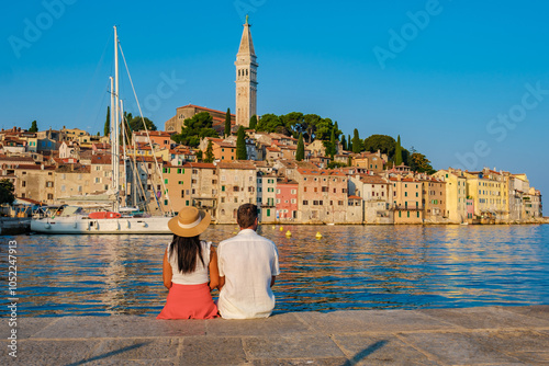 Couple enjoying a sunset by the waterfront in Rovinj, Croatia, amidst vibrant architecture
