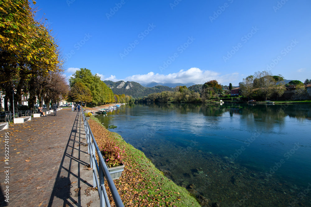 Fototapeta premium Along the lakeside of the river Adda with its beautiful autumn colors, fishing boats and wild nature
