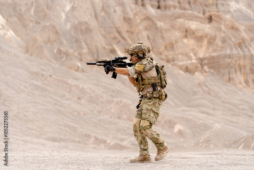 Side view of military or soldier with hold gun and point forward also walk in battlefield near the mountain during outdoor practice.