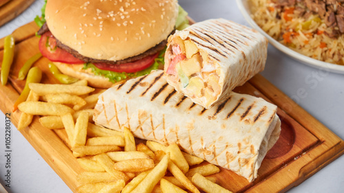 Tasty doner kebab with fries and burger on white background