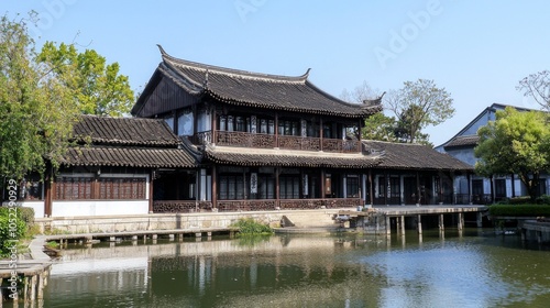 Chinese-style building, close-up view of the house, with a small river in front of house and blue sky.