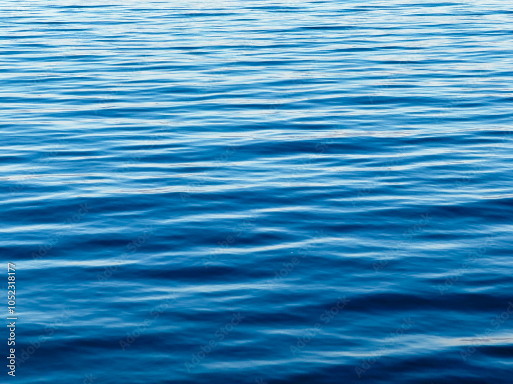 Texture of blue calm water creates a serene and peaceful background. The natural beauty of water reflects the essence of nature, evoking a sense of tranquility reminiscent of the sea. Texture of blue calm water creates a serene and peaceful background. The natural beauty of water reflects the essence of nature, evoking a sense of tranquility reminiscent of the sea.