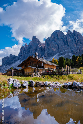 A picturesque autumn afternoon in the Dolomites with a quaint cabin reflecting on tranquil waters photo