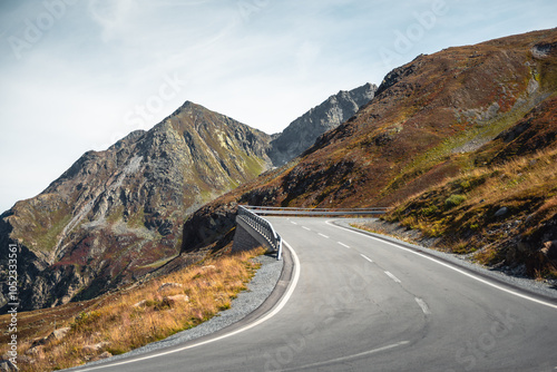 Flüela Pass mountain road on sunny afternoon. Mountain pass hairpin in Swiss apps, Piz dal Ras and Piz Murtaröl peaks of Albula alps in the background. photo