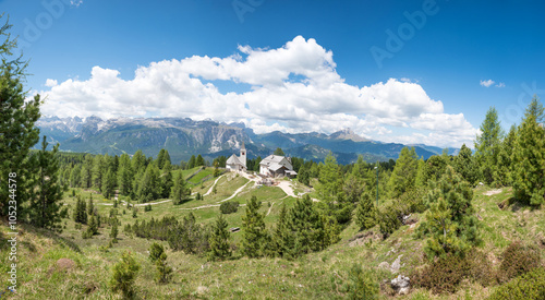 beautiful view from Heiligkreuzkofel mountain trail, to dolomites alps, santa croce church and spring forest