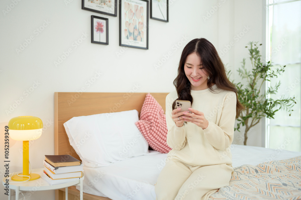 Young asian woman using smart phone lying on bed. Young asian woman using smart phone lying on bed.