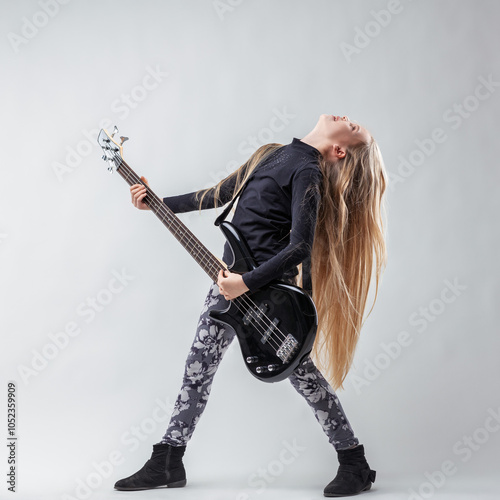 Young talented musician passionately playing bass guitar on whit