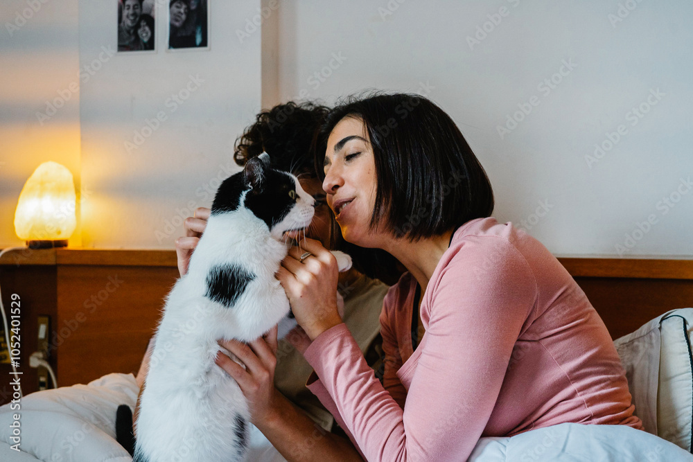 Couple Sharing Affection with Their Cat in Bed Couple Sharing Affection with Their Cat in Bed