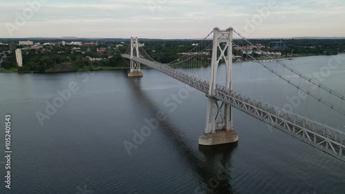 mid hudson bridge (aerial view of suspension bridge in poughkeepsie) cars driving on road across river water (scenic drone footage) cinematic establishing shot valley upstate new york state fall trees photo