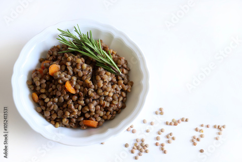 Lenticchie stufate fatte in casa aromatizzate con erbe, contorno o secondo piatto in un piatto bianco isolato su sfondo bianco. Cibo sano e vegetariano. Direttamente sopra. photo