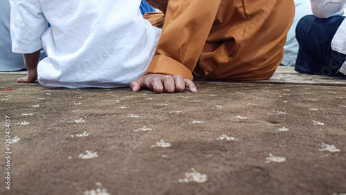 Children's hands on the carpet of the mosque, listening to the sermon during Friday prayers. photo