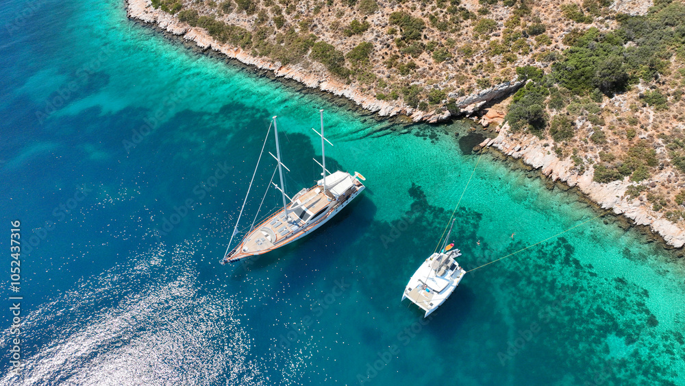 Aerial drone top down photo with copy space of luxury yacht anchored in tropical exotic island with crystal clear turquoise sea