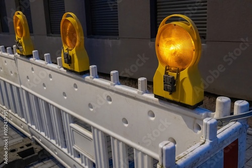 Flashing yellow rotating lights on white roadblock at night protecting construction site photo