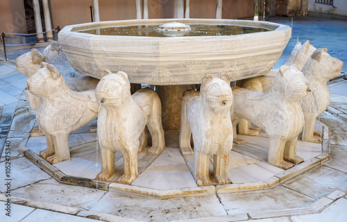 Alhambra palace, Granada, Spain. Twelve marble lion sculptures adorning a fountain, spouting water in the patio de los leones, alhambra, granada, andalusia, spain photo