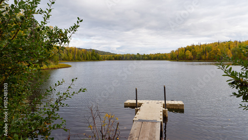 Tranquil view of the beautiful lakes near Talkeetna in autumn colors with a wooden pier in the foreground, Alaska, USA photo