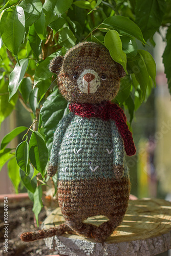 Knitted toy cat near a flower pot, handmade soft toys