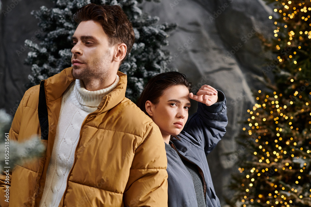 A couple dressed in cozy jackets stands near snow-dusted pines, enjoying a festive winter moment together. A couple dressed in cozy jackets stands near snow-dusted pines, enjoying a festive winter moment together.