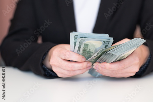 Woman hands holding pile of 100 US dollar banknotes