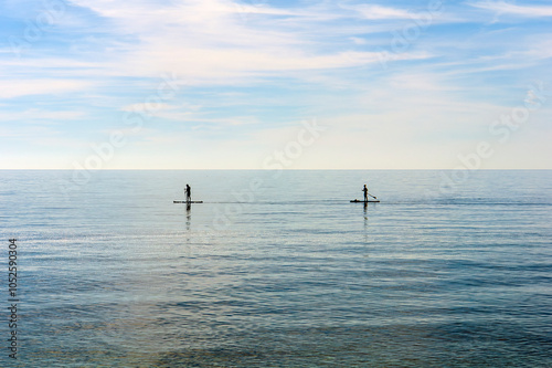 Paisaje marino con dos deportistas practicando padel surf photo