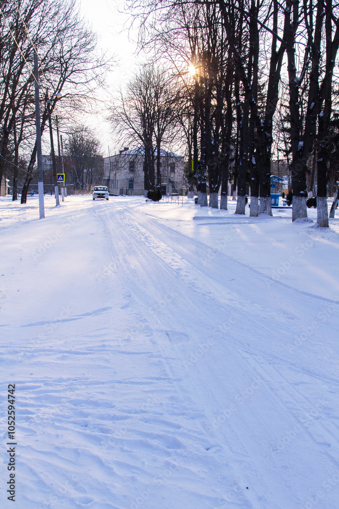 Winter landscape in the rays of the setting sun. City park.