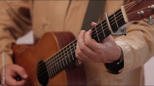 A guitarist plays acoustic guitar in close-up