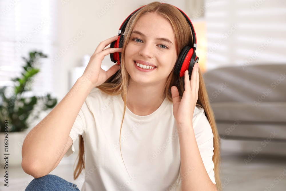 Naklejka premium Portrait of teenage girl in headphones at home