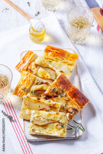 Puff pastry pie with cheese, pears, nuts and honey, served with champagne.