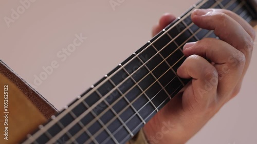A guitarist plays acoustic guitar in close-up