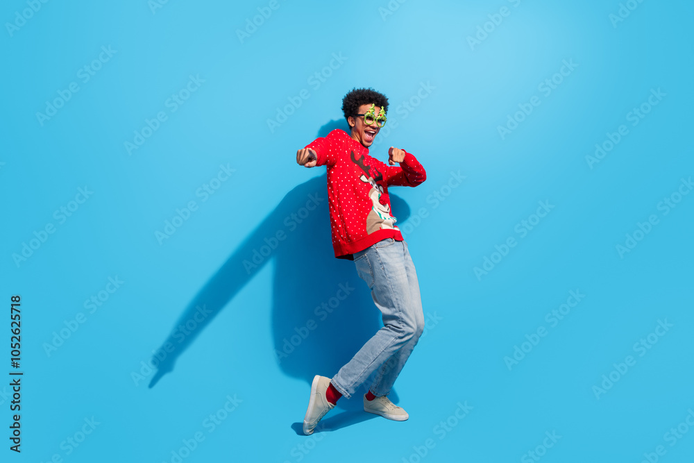 Full length photo of handsome young guy dancing point you dressed red christmas sweater celebrate winter holidays on blue background Full length photo of handsome young guy dancing point you dressed red christmas sweater celebrate winter holidays on blue background
