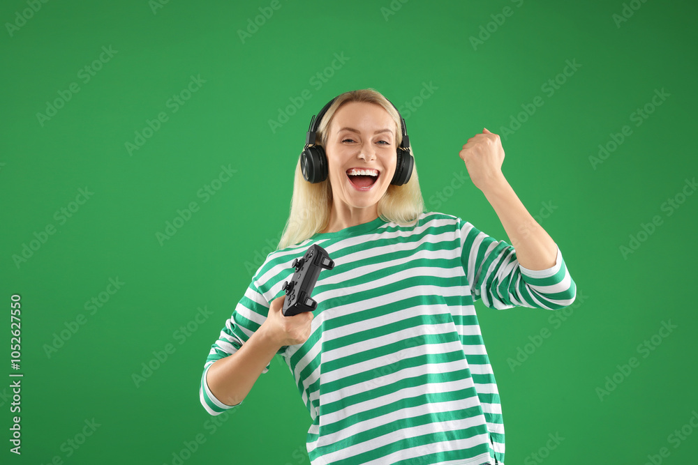Happy woman in headphones with controller on green background Happy woman in headphones with controller on green background