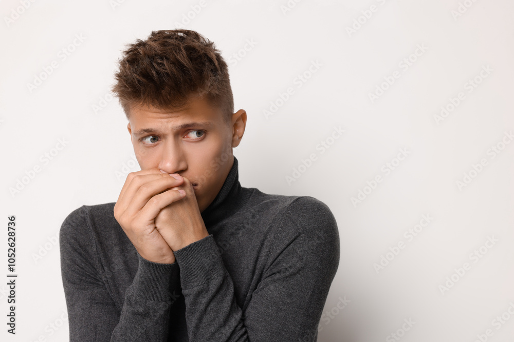 Portrait of scared young man on light background, space for text Portrait of scared young man on light background, space for text