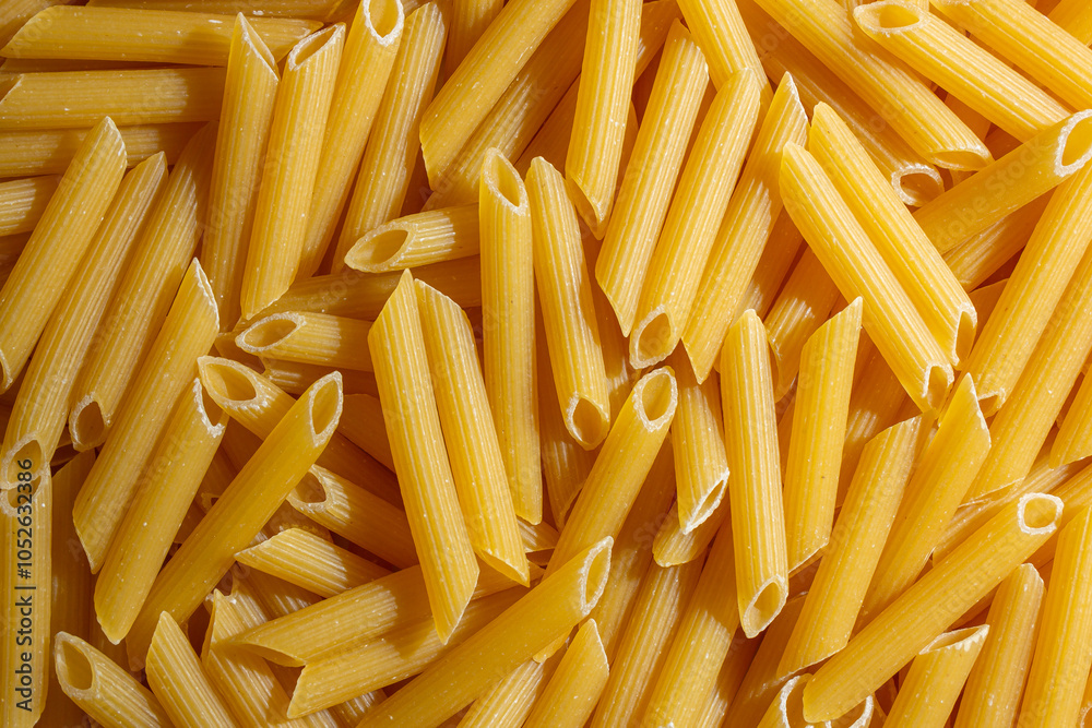 Uncooked Penne Rigate Pasta: A Culinary Canvas of Penne Macaroni, Creating a Lively and Textured Background for Gourmet Cooking. Dry Pasta. Raw Macaroni - Top View, Flat Lay Uncooked Penne Rigate Pasta: A Culinary Canvas of Penne Macaroni, Creating a Lively and Textured Background for Gourmet Cooking. Dry Pasta. Raw Macaroni - Top View, Flat Lay