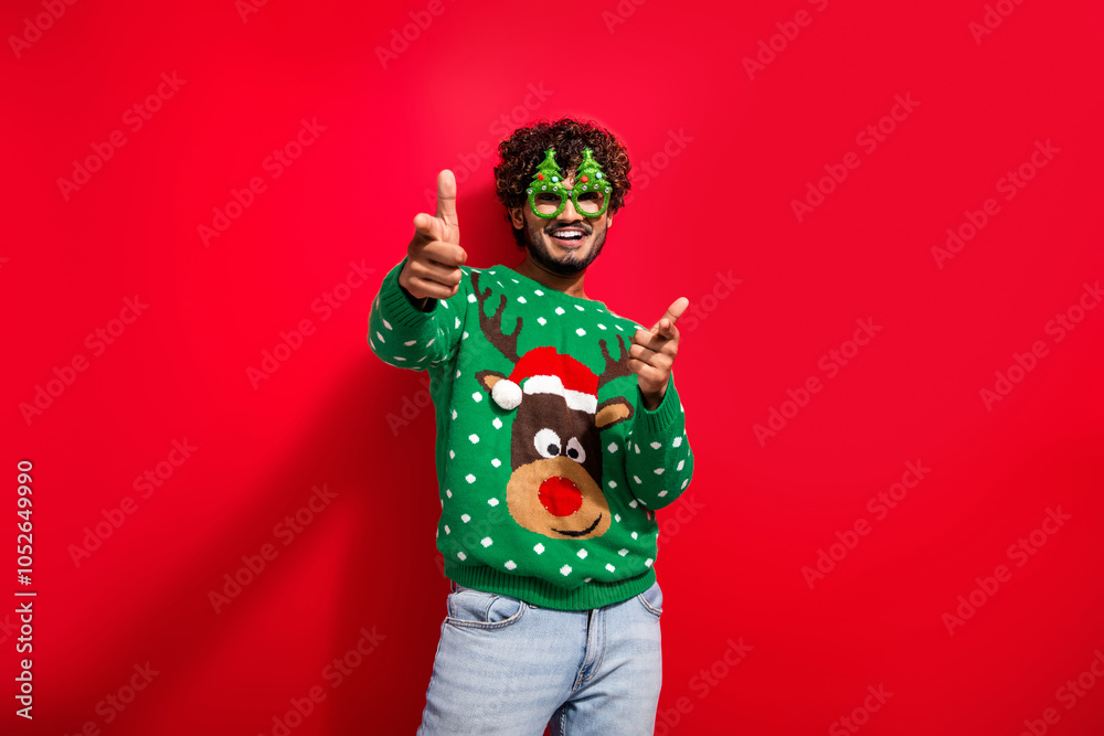 Photo of nice young man point fingers you empty space wear christmas sweater isolated on red color background Photo of nice young man point fingers you empty space wear christmas sweater isolated on red color background
