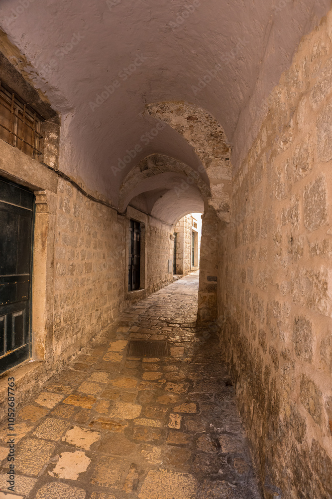 Fototapeta premium Medieval stone arched corridor with a stone floor